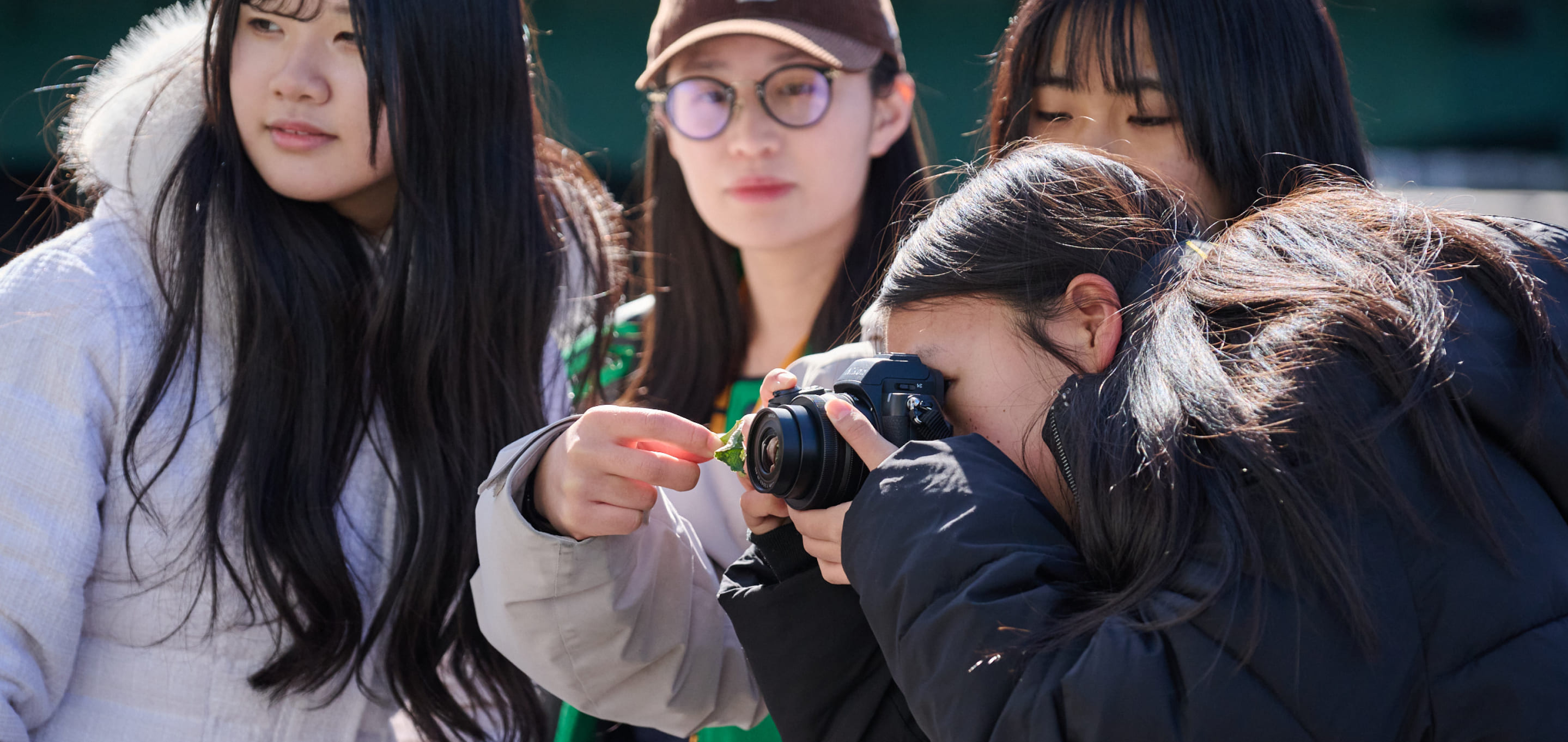 女性の生徒達がカメラで撮影をしている写真