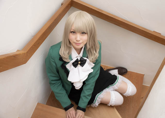 階段に座り、こちらを見上げる女性の写真。