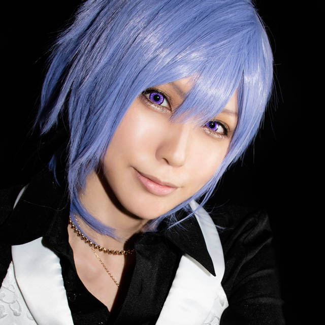 こちらに向かって手を伸ばし、何かを語りかけるような男装の女性の写真。