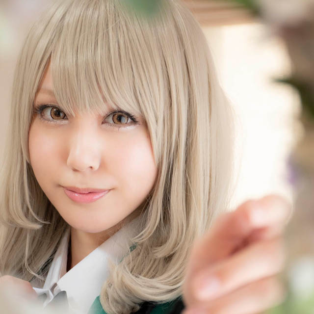 奥に立つ女性にフォーカスすることで手前の花がぼけ、ふんわりとした縁取りのように見える写真。