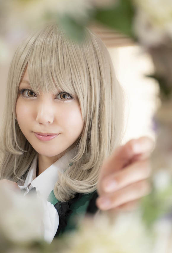 奥に立つ女性にフォーカスすることで手前の花がぼけ、ふんわりとした縁取りのように見える写真。