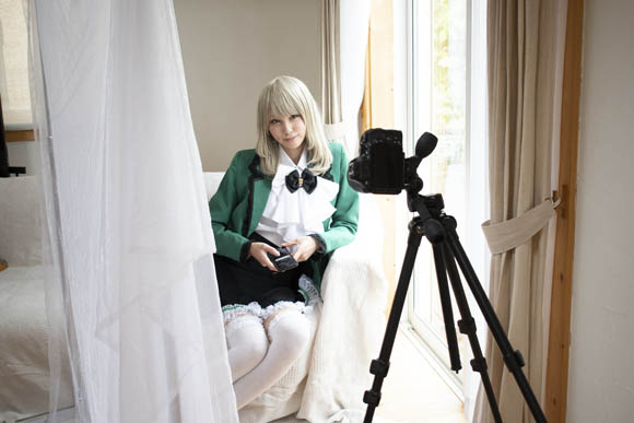 やわらかい自然光を活かした、窓際のソファに座る女性の写真の撮影風景。