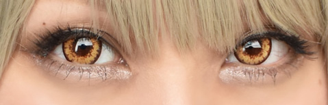 瞳に光が写り込み生き生きとした表情で微笑むの女性の両目部分の拡大写真。