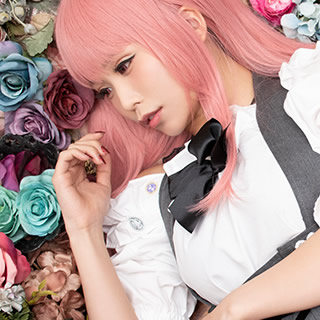 色とりどりの花の中に寝ころぶ女性の写真。