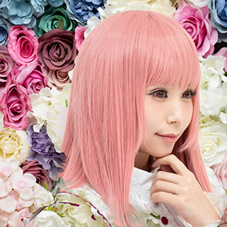 色とりどりの花の中で微笑む女性の写真。