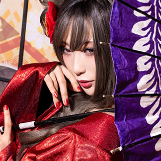 紫の和傘を肩にかけ、こちらを振り返る赤い着物の女性の写真。