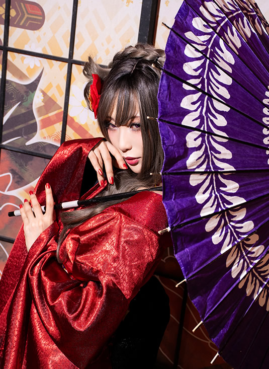紫の和傘を肩にかけ、こちらを振り返る赤い着物の女性の写真。