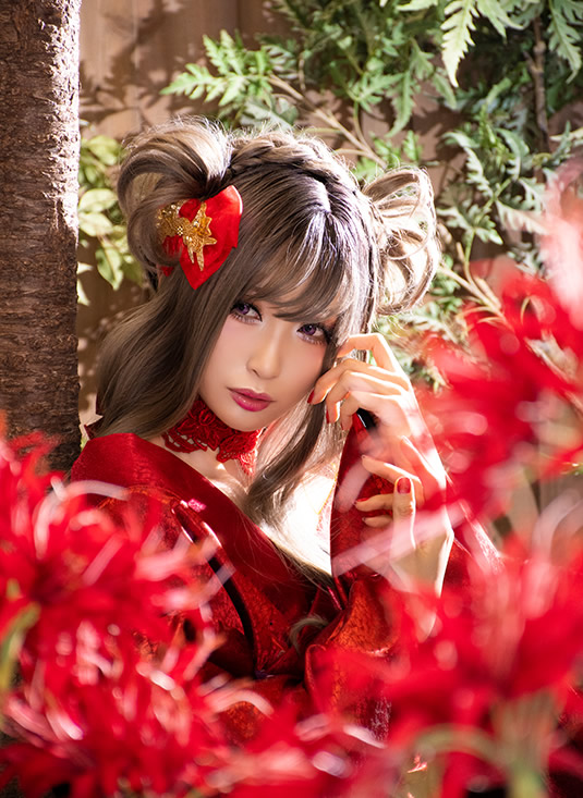 彼岸花越しに赤い着物の女性を撮影した写真。