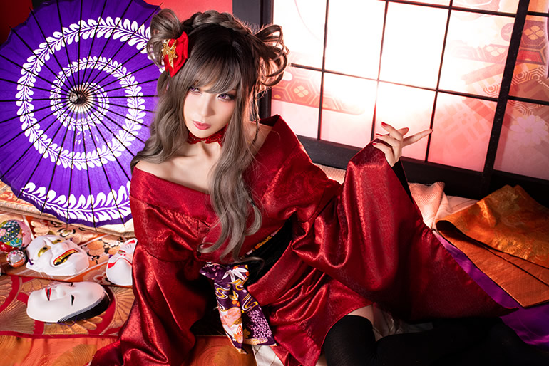 障子越しに光が射す和室で横座りする赤い着物の女性の写真。