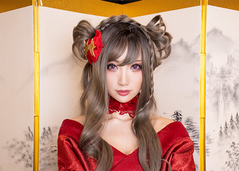 屏風の前に座り、こちらを見つめる赤い着物の女性の写真（スピードライトを使用した例）。