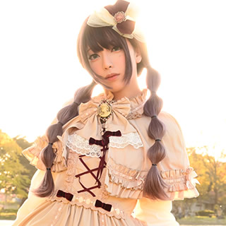 川沿いに立ち、真正面を向いてポーズを決める女性の写真。