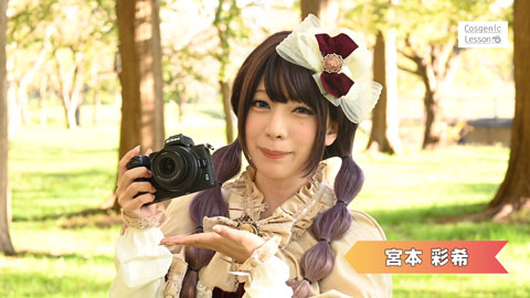 木立の中、カメラを手にコメントする女性の写真（動画サムネイル）。