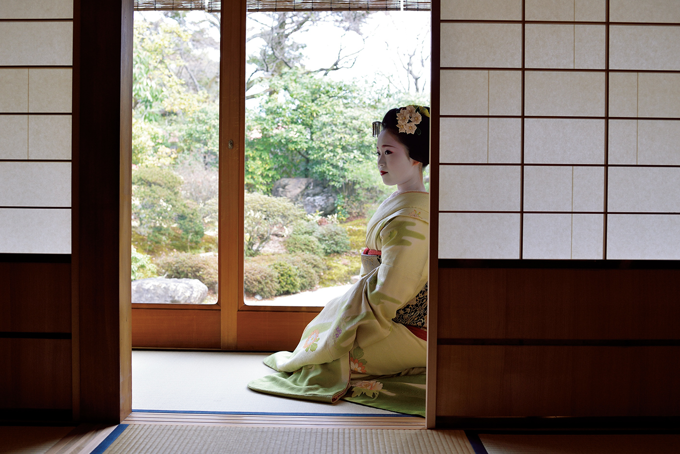 はりのある肌の質感、おふくに結った髪の生え際や髪飾り、春を感じさせる利休地の着物の柄を克明に描写。