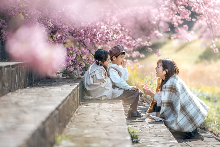 花を背景に楽しそうな家族の写真
