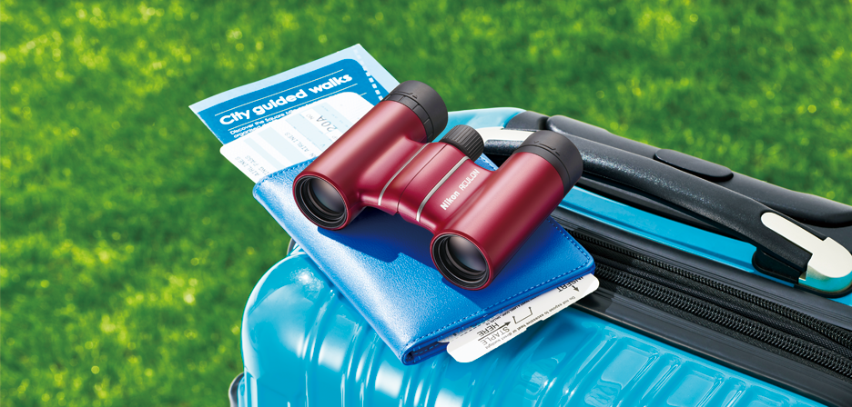 スーツケースの上に置かれた双眼鏡のイメージ