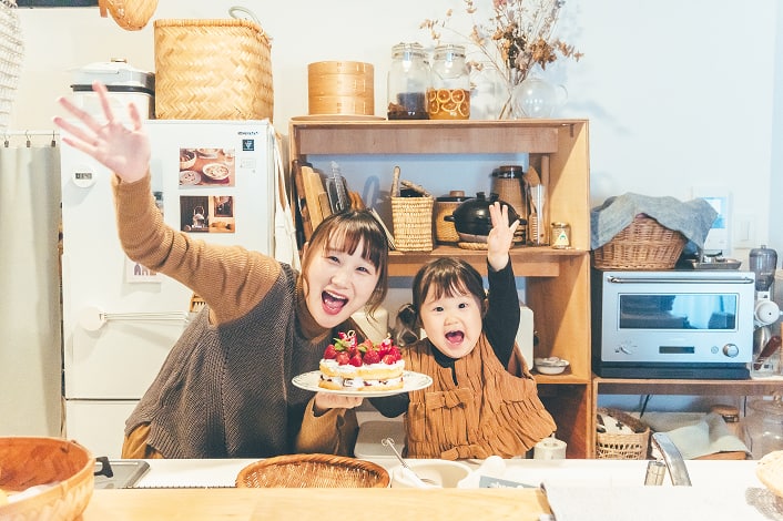 ケーキを持ちポーズを決めている家族写真