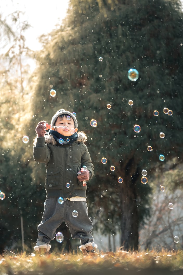 シャボン玉で遊んでいる男の子の写真