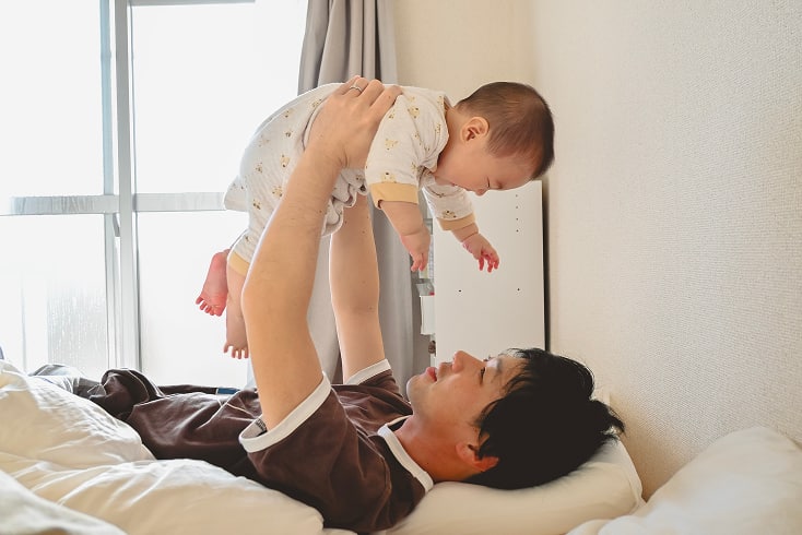 父親が赤ちゃんをあやしている様子の写真