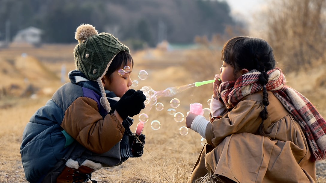 子どもたちがシャボン玉で遊んでいる写真
